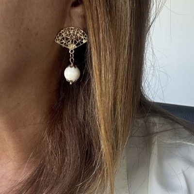 Brinco dourado em forma de leque com esfera branca pendente