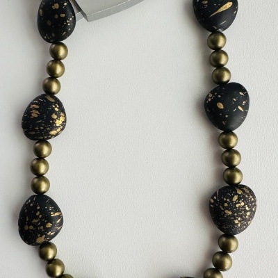 Colar com contas negras e douradas e objeto metálico em forma de coração com texto BE SMILE