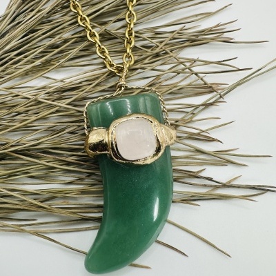 Colar com pendente verde e detalhes dourados sobre ramos secos