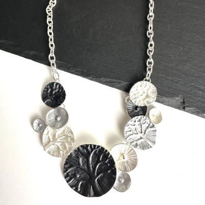 Colar com discos texturizados pretos e prateados