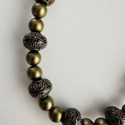 Colar de contas douradas com padrões gravados