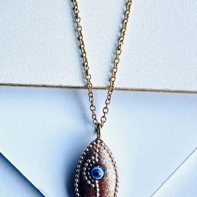 Colar dourado com pendente em forma de peixe castanho e dourado com olho azul