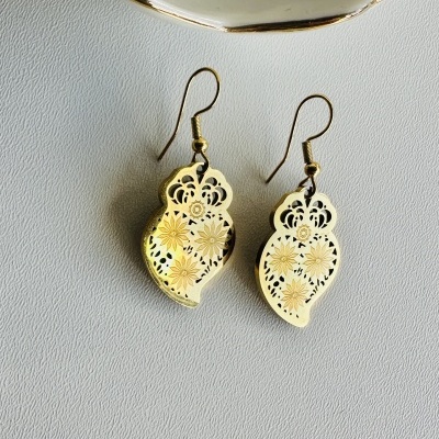 Brincos dourados perfurados com padrão floral e ganchos para orelha sobre fundo branco