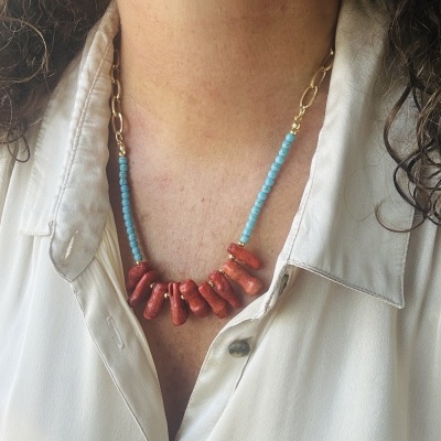 Colar com contas azuis e pedras vermelhas em corrente dourada