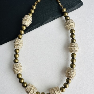 Colar com contas creme esculpidas e contas metálicas douradas