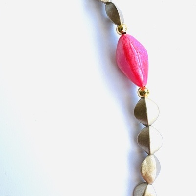 Colar com contas douradas e contas rosas em fundo branco