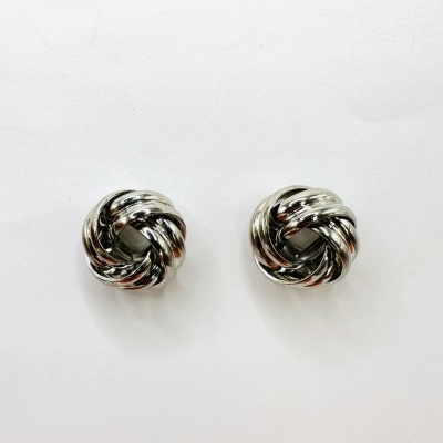 Brincos metálicos prateados em forma de nó sobre fundo branco