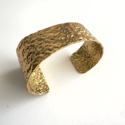 Pulseira dourada em metal com textura martelada