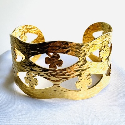 Bracelete dourado com textura martelada e recortes em forma de três folhas
