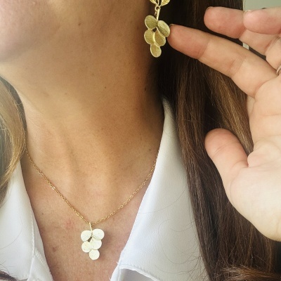 Conjunto de colar e brinco dourados com design de folhas e bagas