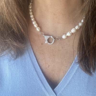 Colar curto de pérolas brancas com fecho prateado e camisola azul clara