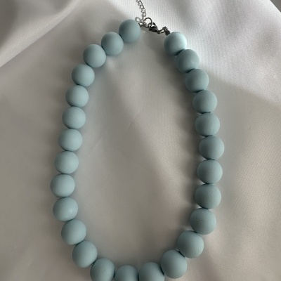 Colar de contas azuis claras sobre fundo branco