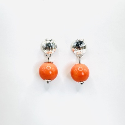 Brincos com pérolas prateadas e bolas laranja brilhante sobre fundo branco