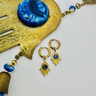 Colar e brincos dourados com design de mão hamsá e detalhes azuis em cerâmica