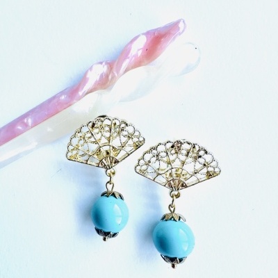 Brincos dourados com pedra azul turquesa e objetos alongados rosa e branco