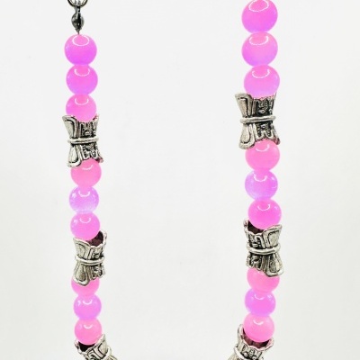 Colar com contas cor de rosa e peças metálicas prateadas em forma de laço