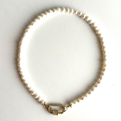 Colar de pérolas brancas com fecho dourado detalhado sobre fundo branco