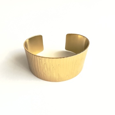 Pulseira metálica dourada com textura de veios de madeira