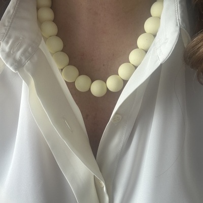 Colar de contas brancas opacas e camisa branca