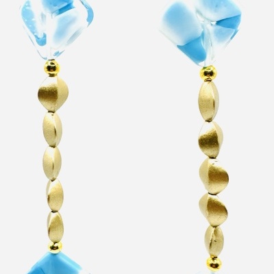 Colar com elos metálicos dourados e contas azuis com padrão branco.