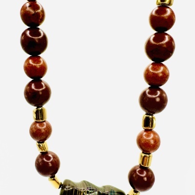 Colar com contas redondas castanho e dourado e conta central verde e preta com padrão riscado.