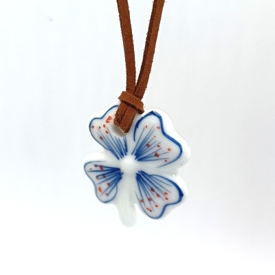 Colar com pingente em forma de flor de porcelana branca com detalhes em azul e vermelho