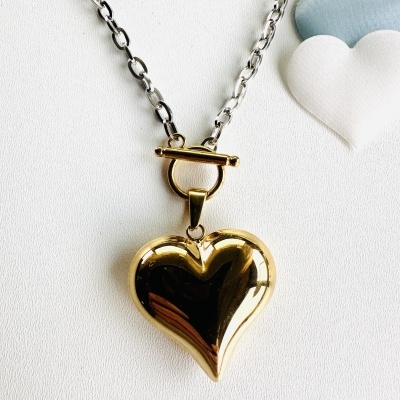 Colar com pendente de coração dourado e corrente prateada, com corações almofadados ao lado