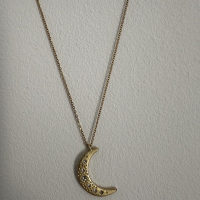 Colar dourado com pendente em forma de lua com pedras brilhantes