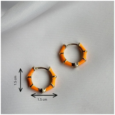 Brincos de argola laranja e dourados sobre fundo branco.