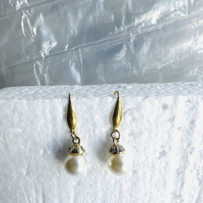 Brincos pendentes dourados com pérola e detalhes prateados