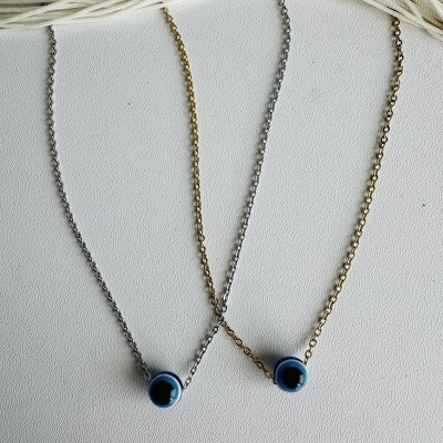 Duas pulseiras com pendente de olho turco, uma prateada e outra dourada, sobre fundo branco.