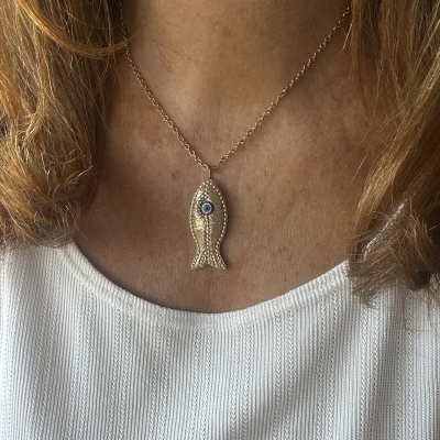 Colar dourado com pingente em forma de peixe e olho azul