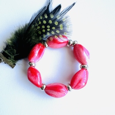 Pulseira rosa com penas pretas e amarelas e espaçadores prateados