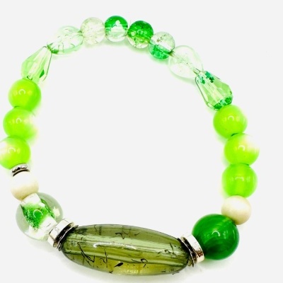 Pulseira elástica com contas verdes, brancas e transparentes sobre fundo branco