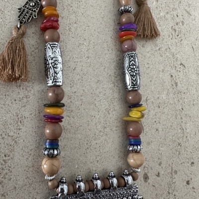 Colar com contas de madeira, elementos metálicos prateados e franjas bege