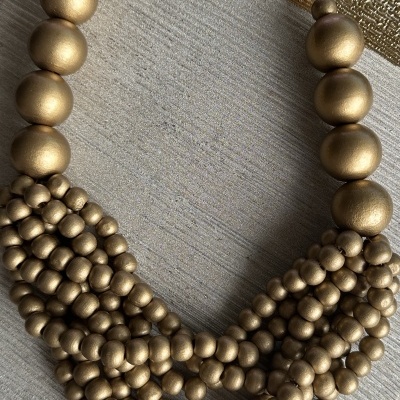 Colar dourado com contas grandes e pequenas em várias camadas