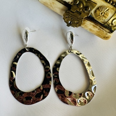 Brincos de metal prateado com textura martelada, forma oval irregular