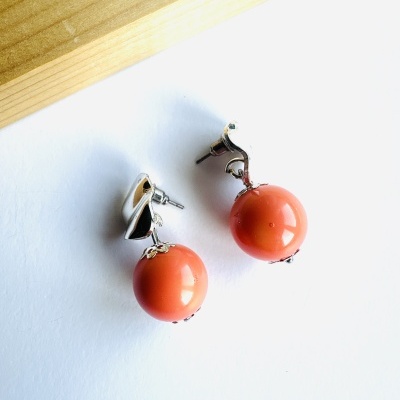 Brincos prateados com pendente esférico laranja