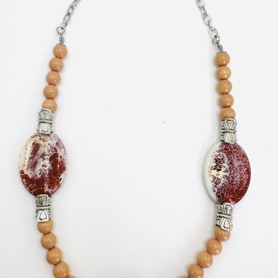 Colar com contas bege e ovais vermelhas e brancas craqueladas com detalhes metálicos prateados