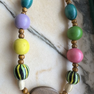 Colar de contas de madeira coloridas sobre mármore