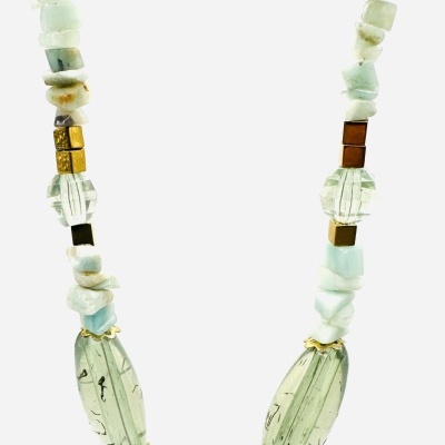 Colar colorido com várias pedras e contas, incluindo uma conta verde central com padrão preto