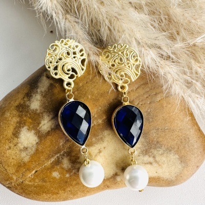 Brincos dourados com pedra azul e pérola em fundo branco com pedra castanha