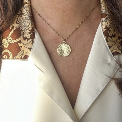 Colar dourado com pendente redondo e relevo em camisa creme com gola estampada castanho e dourado