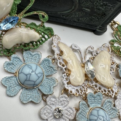Colar com flores e borboletas em esmalte azul e branco com detalhes dourados e cristais