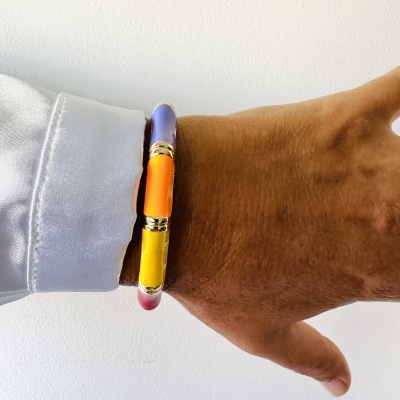 Pulseira rígida colorida usada no pulso direito sobre fundo branco