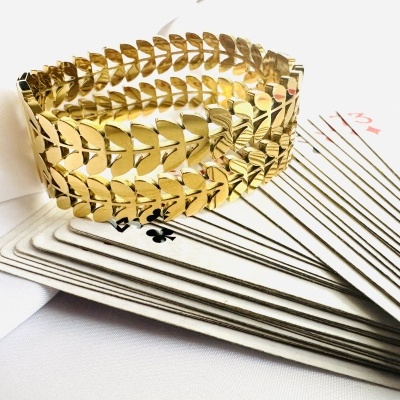 Pulseira dourada sobre baralho de cartas