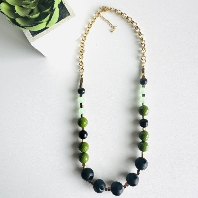 Colar de contas e corrente dourada com planta artificial verde