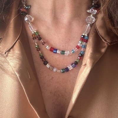 Colar duplo colorido com contas em várias formas e uma camisa dourada acetinada