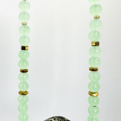 Colar com contas verdes claras e pendente preto com padrão