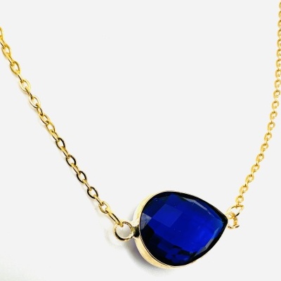 Colar dourado com pedra azul escura em forma de gota
